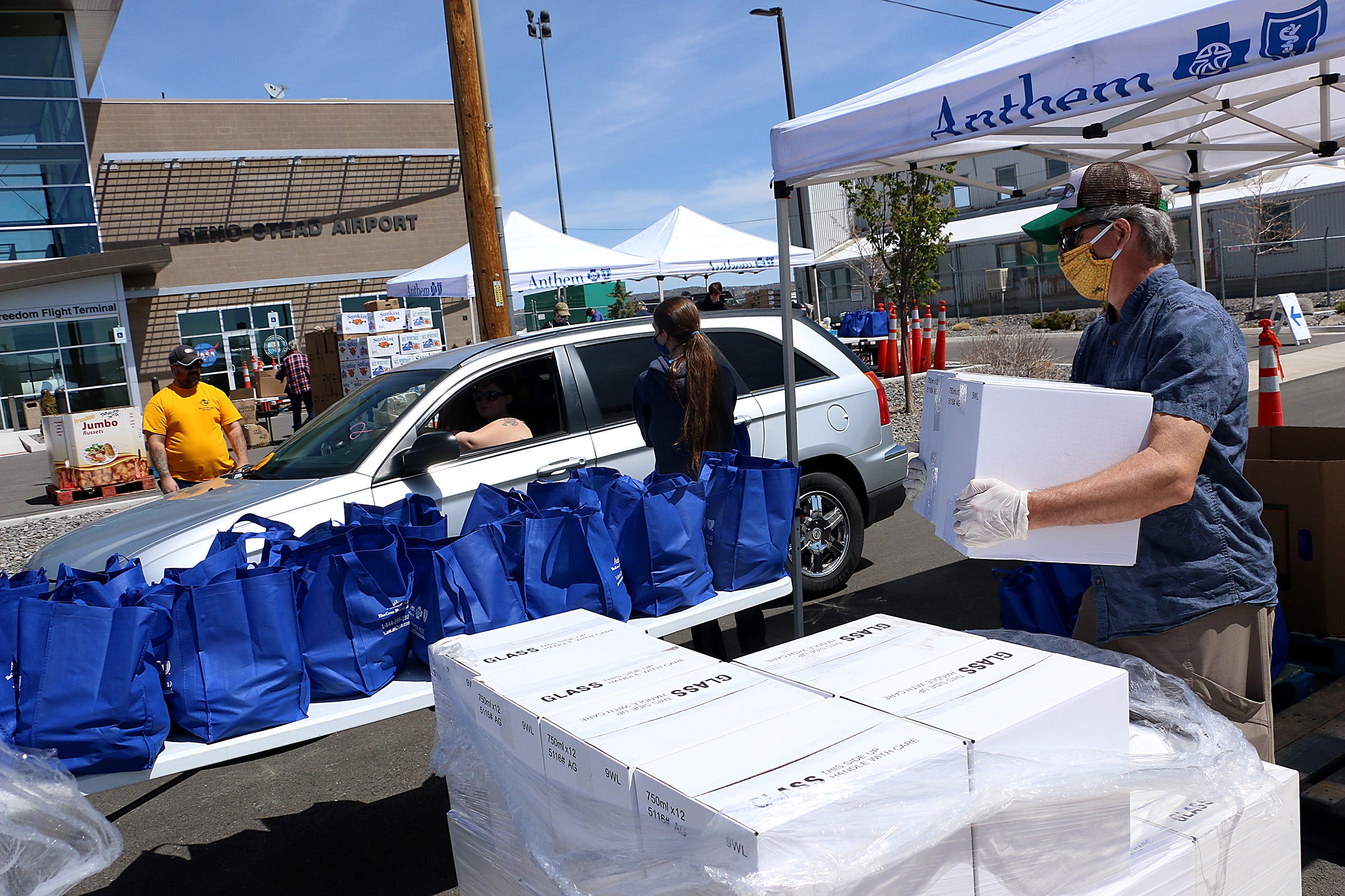 Volunteers with the Food Bank of Northern Nevada pass out food during a Mobile Harvest Food Distribution at the Reno-Stead Airport on April 22, 2020.