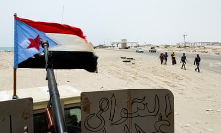 A group of African migrants walks past a checkpoint at the entrance of the port city of Aden