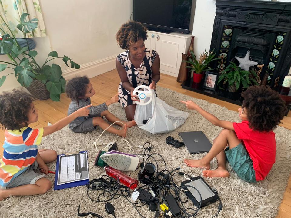 Liz Piggott and her three young sons look through old electrical devices in their home.
