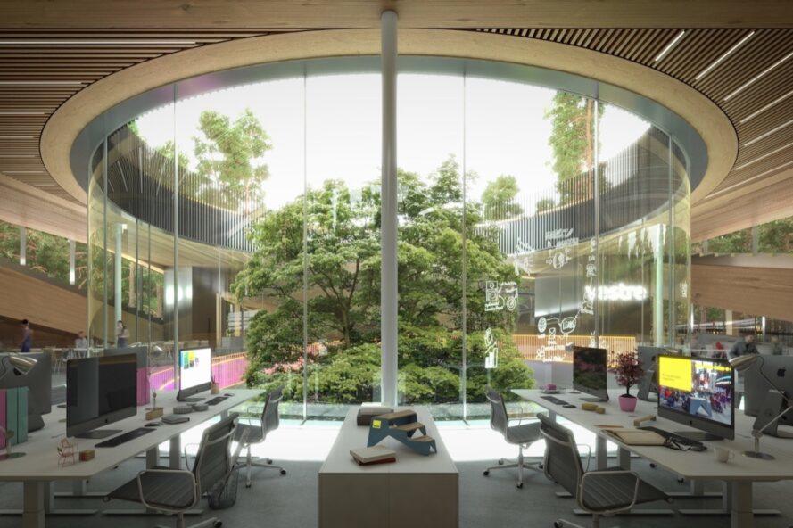 rendering of office desks beside a curved glass wall revealing forest views