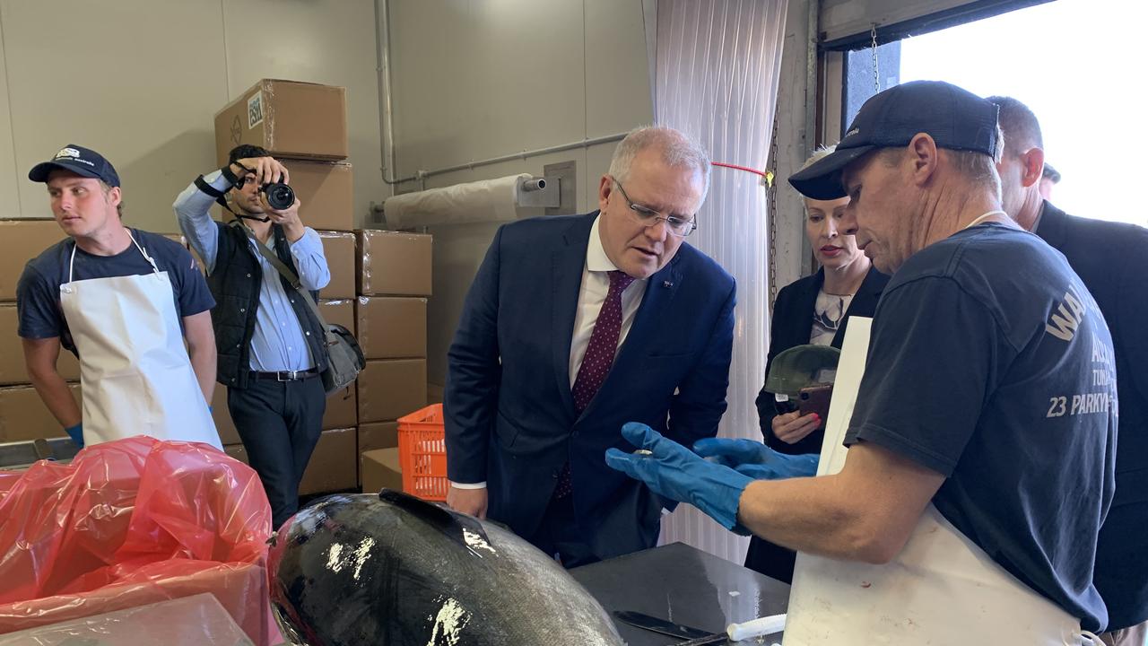 VISIT: Prime Minister Scott Morrison inspecting some of the catch at Walker Seafoods Australia, with owners Pavo and Heidi Walker.