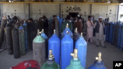 People line up for free oxygen at a privately owned oxygen factory, in Kabul, Afghanistan, Thursday June 18, 2020. For seven years, Najibullah Seddiqi's oxygen factory sat idle in the Afghan capital Kabul.