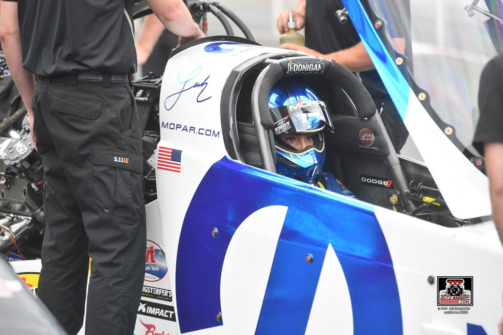 Leah Pruett sits in her Top Fuel car as it readies on the drag strip.