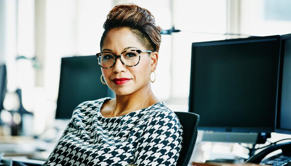 Smiling businesswoman seated at office workstation