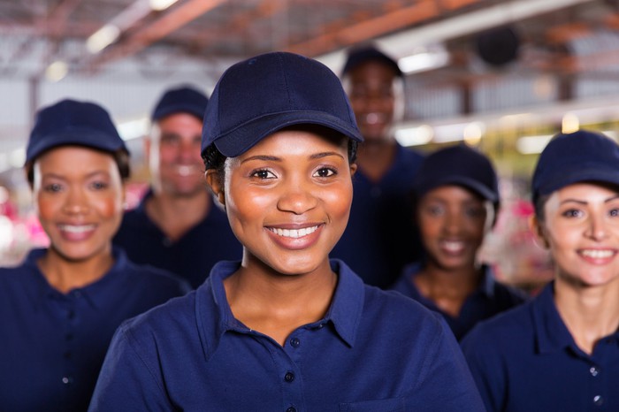 A group of people in matching blue polo shirts and baseball caps