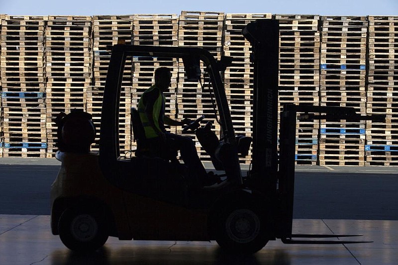 A worker drives a forklift past stacked wooden pallets. (Bloomberg/Andrew Caballero-Reynolds) story.lead_photo.caption