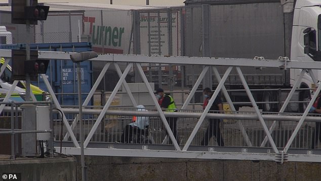Other images showed a suspected migrant being pushed along in a wheelchair by officials in Dover