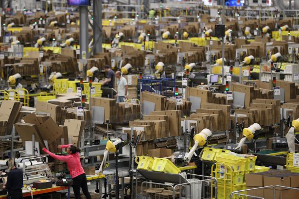 Industrial Conversions Sail Into More Malls as Operators Drop Anchors Humans and machines at work at an Amazon Fulfillment center.