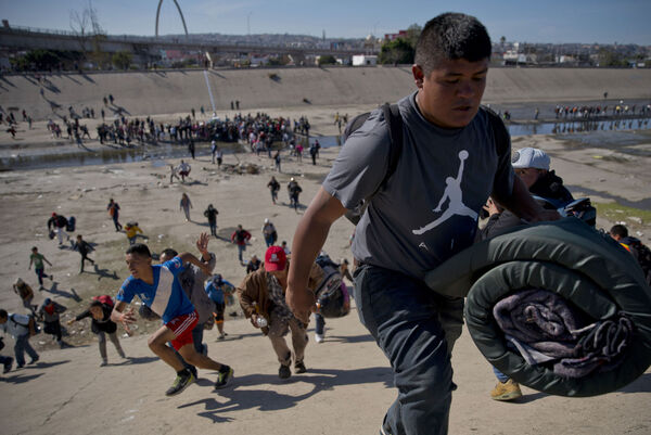 Migrants move up a riverbank at the Mexico-U.S. border after getting past a line of Mexican police at the Chaparral border crossing in Tijuana, Mexico, Sunday, Nov. 25, 2018, as they try to reach the U.S. The mayor of Tijuana has declared a humanitarian crisis in his border city and says that he has asked the United Nations for aid to deal with the approximately 5,000 Central American migrants who have arrived in the city. (AP Photo/Ramon Espinosa)