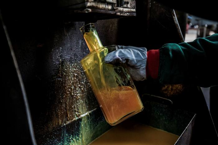 An employee collects diesel at the Duna oil refinery in Hungary. Some energy traders are now diverting resources from their oil desks to carbon credits