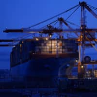 The Maersk Eindhoven container ship, operated by Maersk Line Ltd., is moored next to gantry cranes at a shipping terminal in Yokohama on July 19. | BLOOMBERG