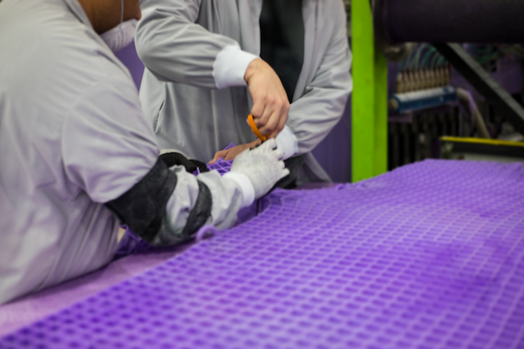 Purple mattress being cut to size