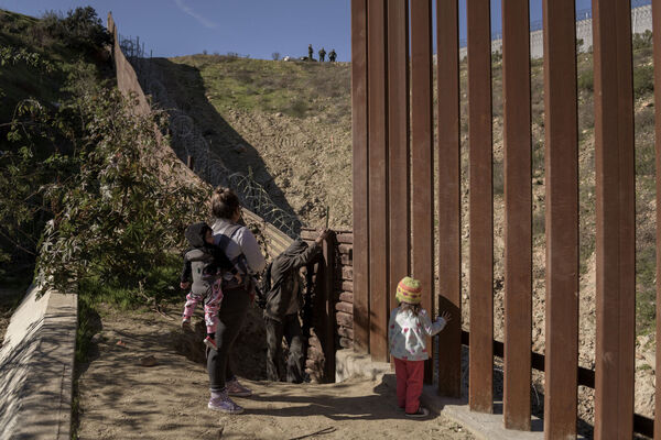 Border Patrol officers, top, look as a group of Mexican migrants prepare to jump the border fence to get into the U.S. side to San Diego, Calif., from Tijuana, Mexico, Saturday, Dec. 29, 2018. (AP Photo/Daniel Ochoa de Olza)