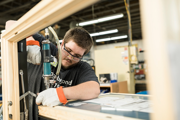 Facility worker assembling a window.