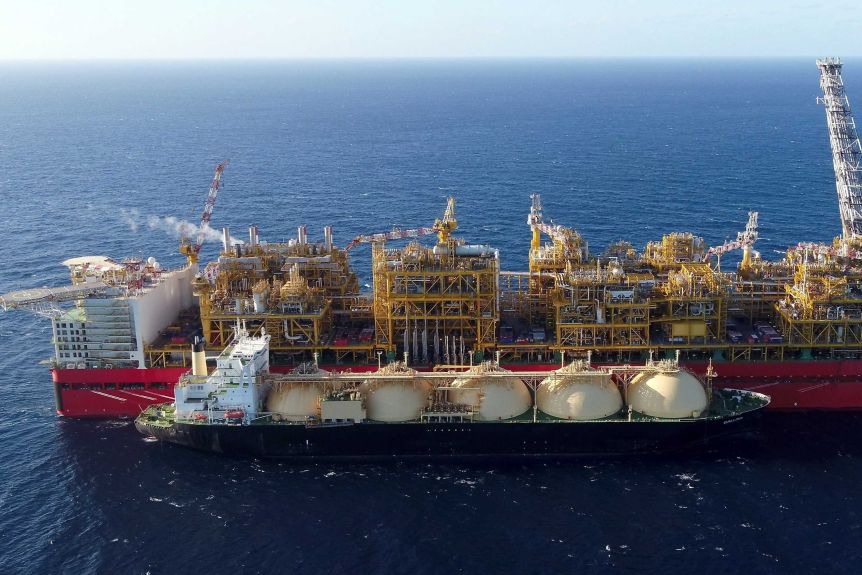 A large red vessel floating in the sea.