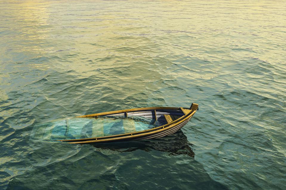 Abandoned sinking rowboat in ocean