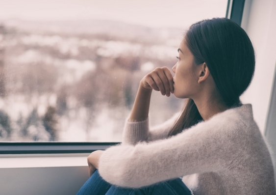 A woman looks out a window