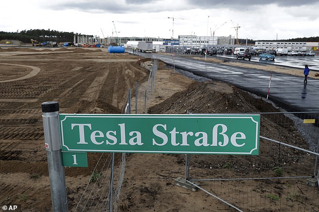 A street sign reading 'Tesla Street 1' stands in front of the construction site of the electric car Tesla Gigafactory in Gruenheide