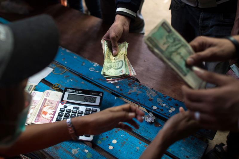This photo taken on July 6, 2017 shows migrant workers changing money from Thai baht to Myanmar kyat at the Myanmar imigration office in Myawaddy. (AFP) This photo taken on July 6, 2017 shows migrant workers changing money from Thai baht to Myanmar kyat at the Myanmar imigration office in Myawaddy. (AFP)