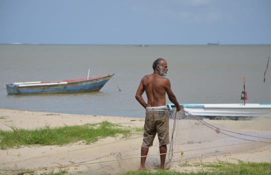 A fisherman pulls his nets from the Gulf of Paria in Trinidad and Tobago.