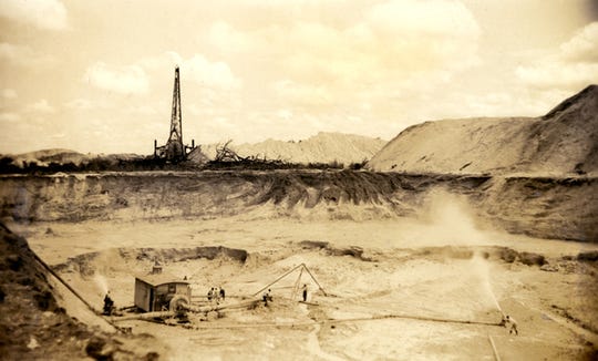 Swift & Co. miners creating slurry with pressurized water at a phosphate rock mine, photo dated 1941