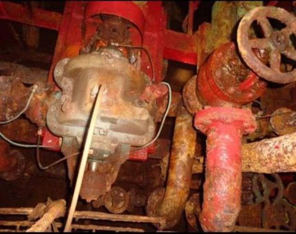 Corroded valves and piping inside an oil tanker.