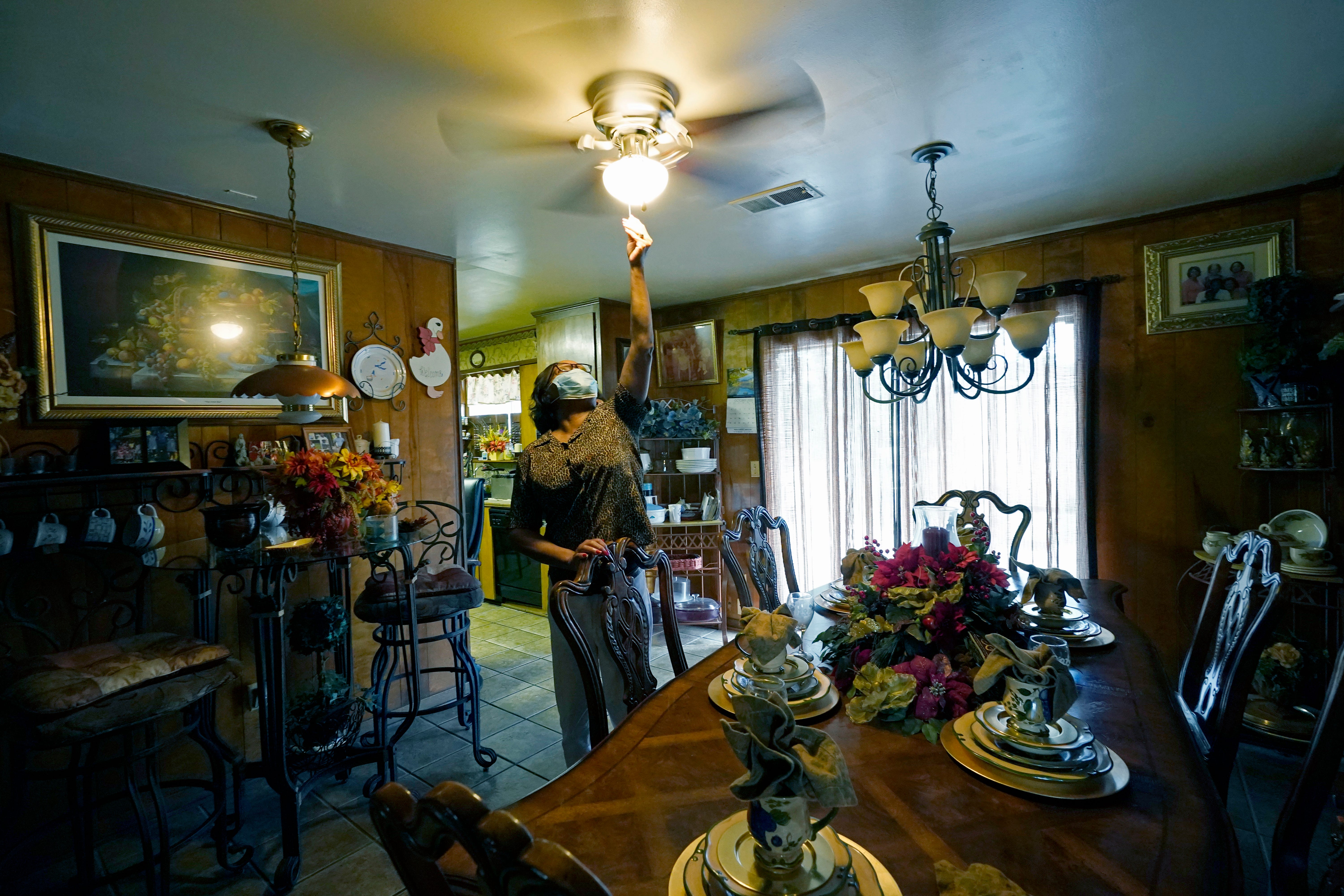 Birdia Williams turns on her ceiling fan onThursday, Oct. 22, 2020, to help cool the house she and her husband John Williams, 23 years ago in Itta Bena, Miss., home a few blocks from what was then a busy downtown. Now, the couple, living on a fix income as retirees, constantly worry on how to budget to compensate for what they believe are high electric bills from the city-run and owned utility. Because of a long standing debt with the wholesale electrical provider, the Municipal Energy Agency of Mississippi, the city is facing complete disconnection on Dec. 1. (AP Photo/Rogelio V. Solis)