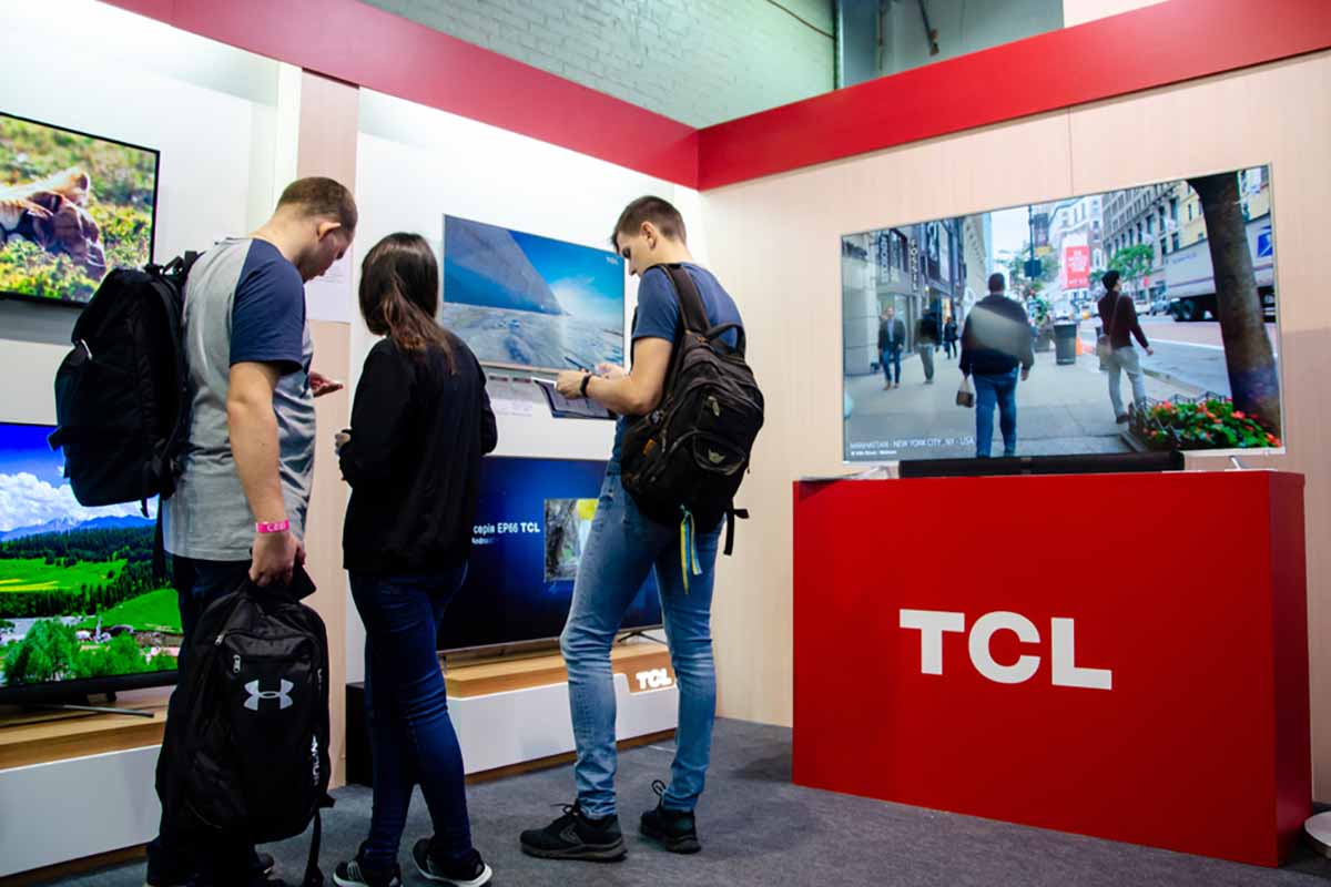 Shoppers in store looking at TCL televisions.