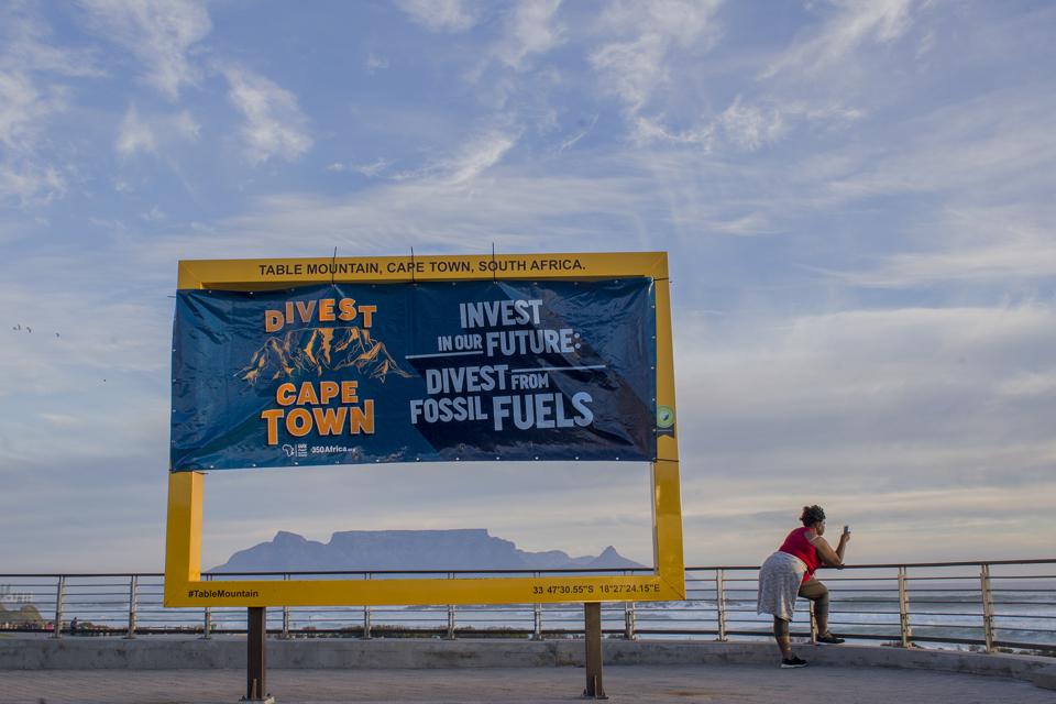 CAPE TOWN, SOUTH AFRICA, May 10, 2017. A 350Africa banner calling for Cape Town to divest from harmful fossil fuels hangs over a view of Table Mountain from one of Cape Town’s New7Wonders of Nature yellow frames in Blouberg, Cape Town, South Africa.