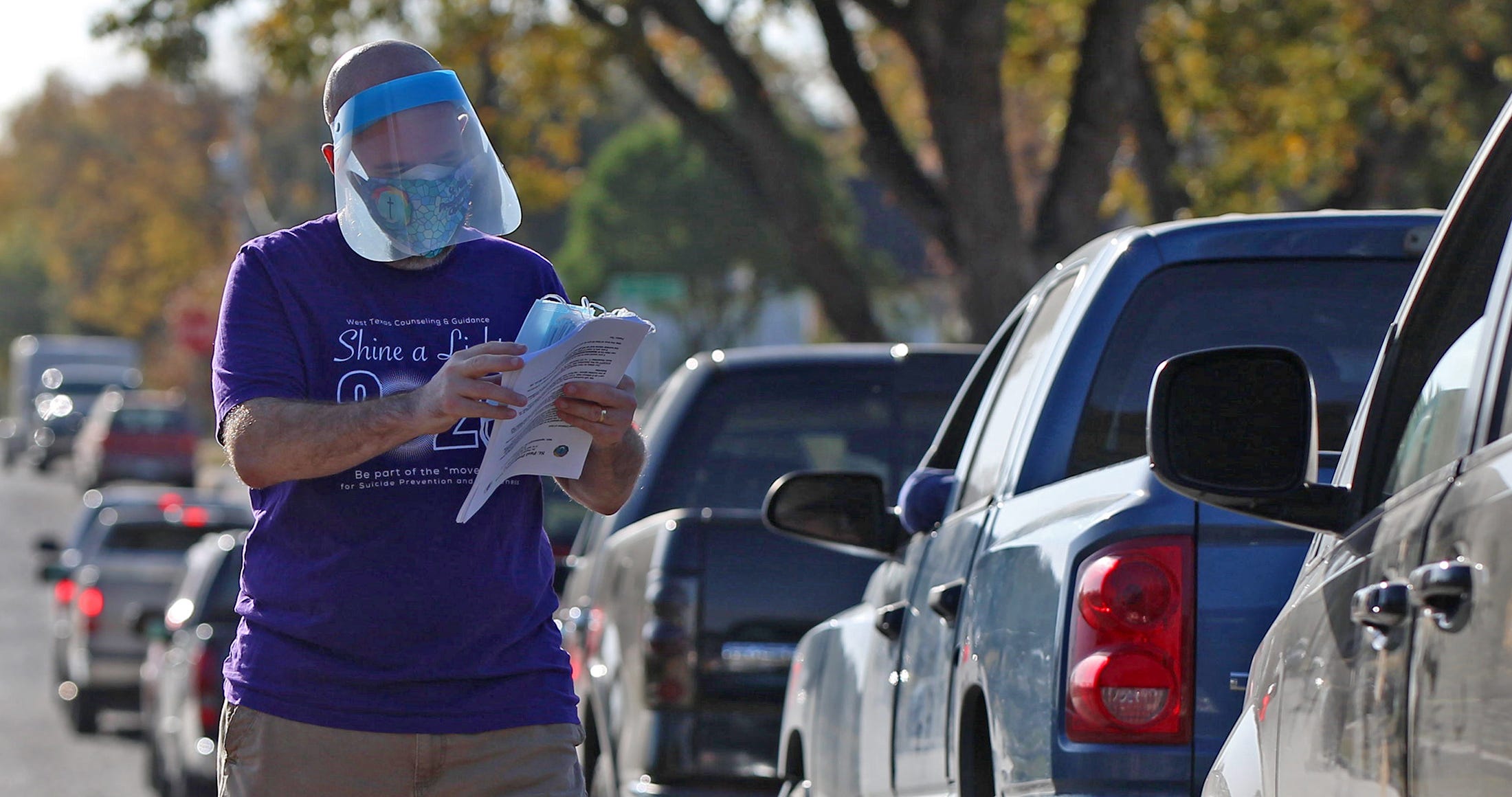 Pastor Timothy Davenport-Herbst directs traffic during a food distribution event at the St. Paul Presbyterian Church on Saturday, Nov. 21, 2020.