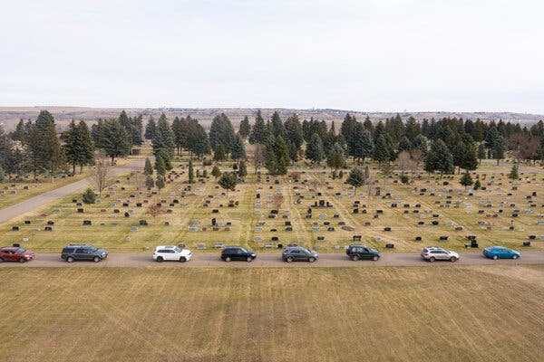 Cars waiting in line at a cemetery for testing in Mandan, N.D., on Wednesday. More than 12.2 million coronavirus cases have been reported in the United States, and more than 256,000 people have died.