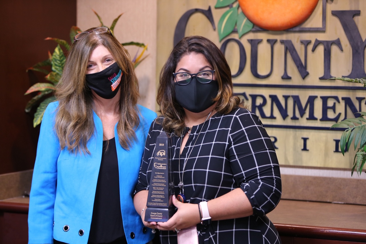Two women holding an award