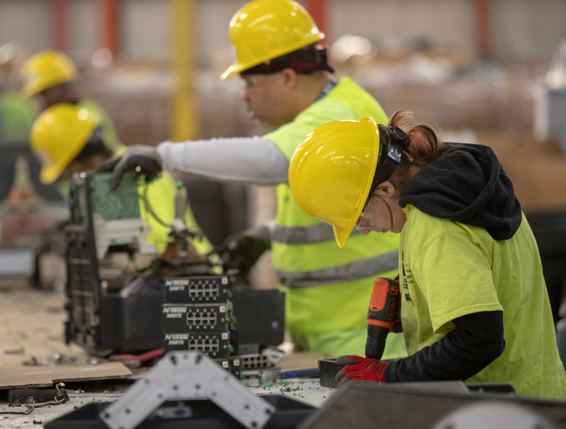 Workers use tools to separate items at Recycle Force, Wednesday, Jan. 8, 2020.