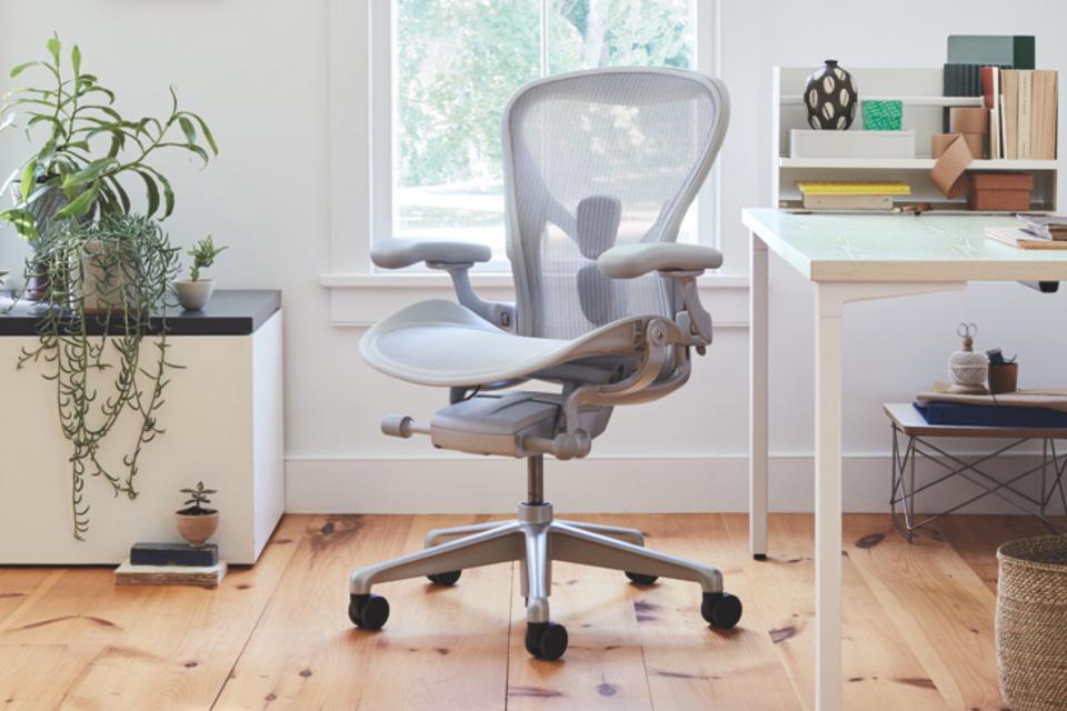 Gray Herman Miller office chair set up on hardwood floor next to a desk.