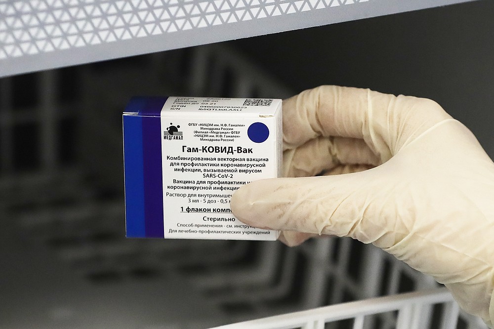 A medical worker moves a box of Russia's Sputnik V coronavirus vaccine out from a refrigerator prior to administering a vaccination in Moscow, Russia, Saturday, Dec. 5, 2020. Thousands of doctors, teachers and others in high-risk groups have signed up for COVID-19 vaccinations in Moscow starting Saturday, a precursor to a sweeping Russia-wide immunization effort. (AP Photo/Pavel Golovkin)