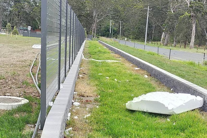 Broken pieces of polystyrene waffle pod strewn across a field.