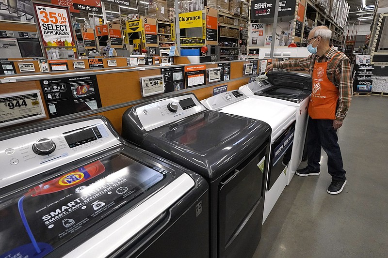 Worker Javad Memarzadeh, of Needham, Mass., right, dusts washers in a display, Thursday, Oct. 29, 2020, at a Home Depot location, in Boston. Orders to U.S. factories for big-ticketed manufactured goods rose a moderate 0.9% in November with a key category that tracks business investment plans showing a gain. The Commerce Department said Wednesday, Dec. 23 that the November gain in orders for durable goods, items expected to last at least three years, followed stronger gains in recent months including a 3.8% rise in October.(AP Photo/Steven Senne) story.lead_photo.caption
