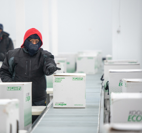 A worker at McKesson's Olive Branch, Miss. distribution center prepares packed and sealed cooler boxes containing Moderna COVID-19 vaccine doses for shipment. (Photo: Business Wire)