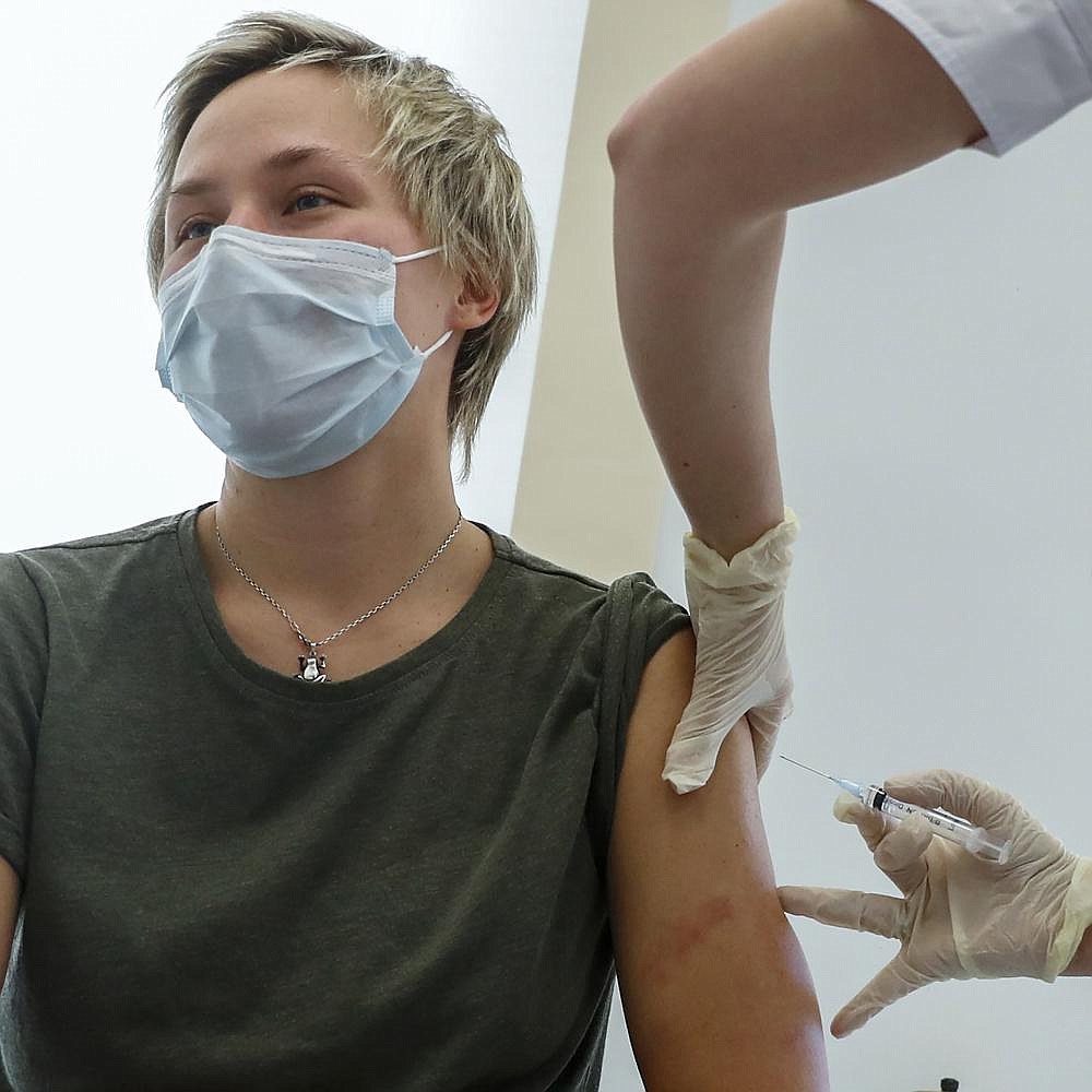 A Russian medical worker inoculates a woman with the Sputnik V coronavirus vaccine Saturday in Moscow. The city opened 70 vaccination facilities Saturday, and more than 5,000 doctors, teachers and others in high-risk groups had already signed up in a precursor to a nationwide immunization effort. More photos at arkansasonline.com/126covid/.
(AP/Pavel Golovkin)