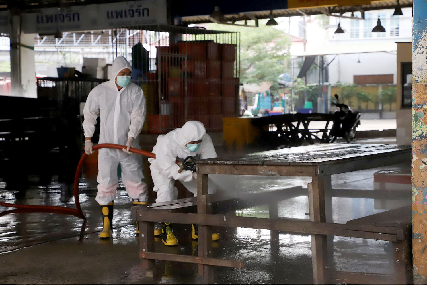 Workers spray disinfectant at the shrimp market in Samut Sakhon on Friday, as authorities try to contain the spread of coronavirus first detected in a shrimp vendor. (Photo from Samut Sakhon Public Relations Office Facebook page) Workers spray disinfectant at the shrimp market in Samut Sakhon on Friday, as authorities try to contain the spread of coronavirus first detected in a shrimp vendor. (Photo from Samut Sakhon Public Relations Office Facebook page)