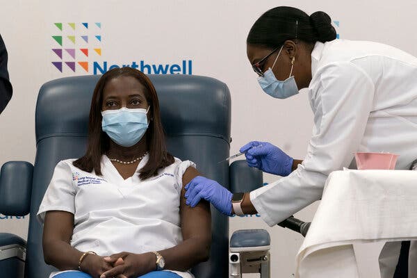 Sandra Lindsay, a nurse at Long Island Jewish Medical Center, is inoculated with the Pfizer-BioNTech Covid-19 vaccine by Dr. Michelle Chester in Queens on Monday.