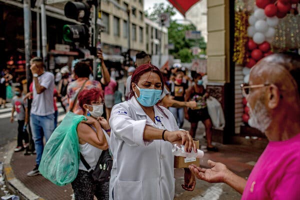 People handing out hand sanitizer on the streets in São Paulo, Brazil, on Friday.