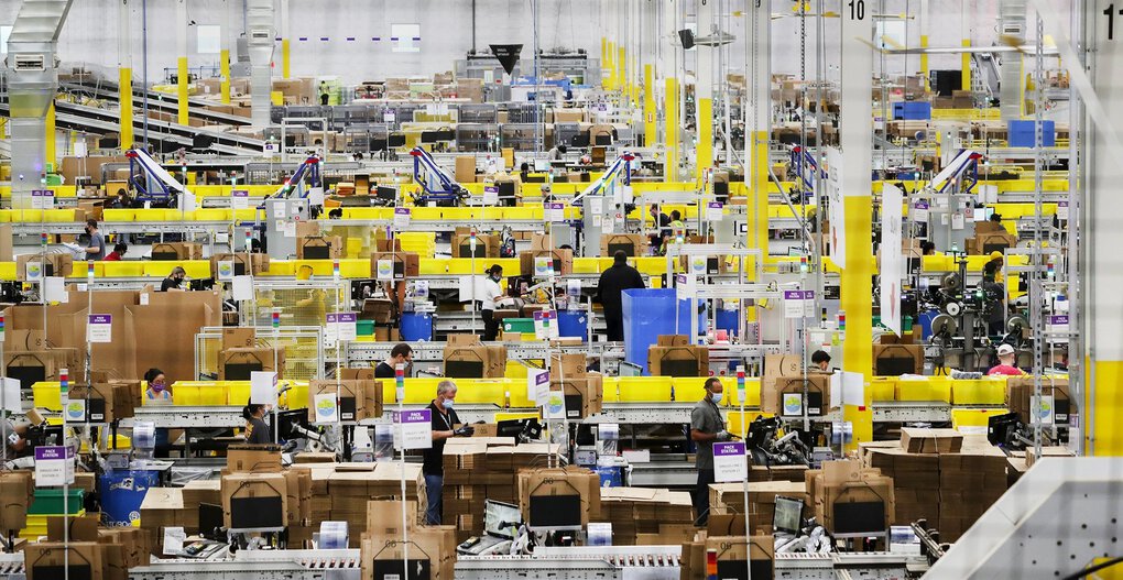 Employees at packing stations work at Amazon’s Kent fulfillment center, a showpiece for the company’s coronavirus response. (Ken Lambert / The Seattle Times)