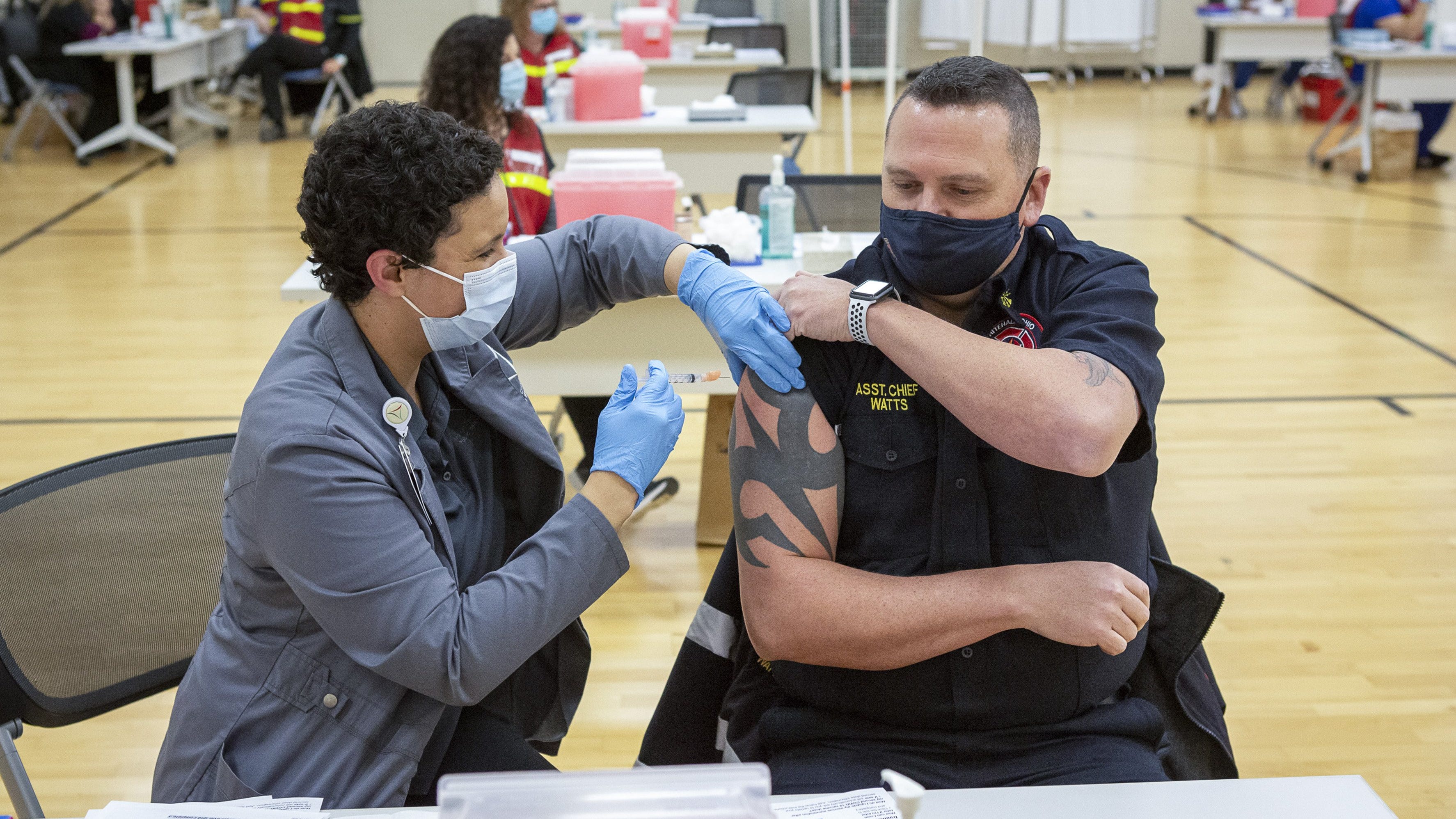 Franklin County assistant health commissioner Alexandria Jones gives a COVID-19 vaccine to Whitehall assistant fire chief KJ Watts on Monday, Dec. 28, 2020. Franklin County Public Health received 4300 doses of the Moderna vaccine and can administer up to 540 per day to those in the first phase of vaccine distribution, which includes EMS responders.