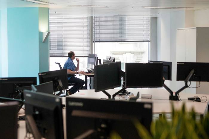 An employee works at a desk during the first phase of the reoccupation of offices in London in June