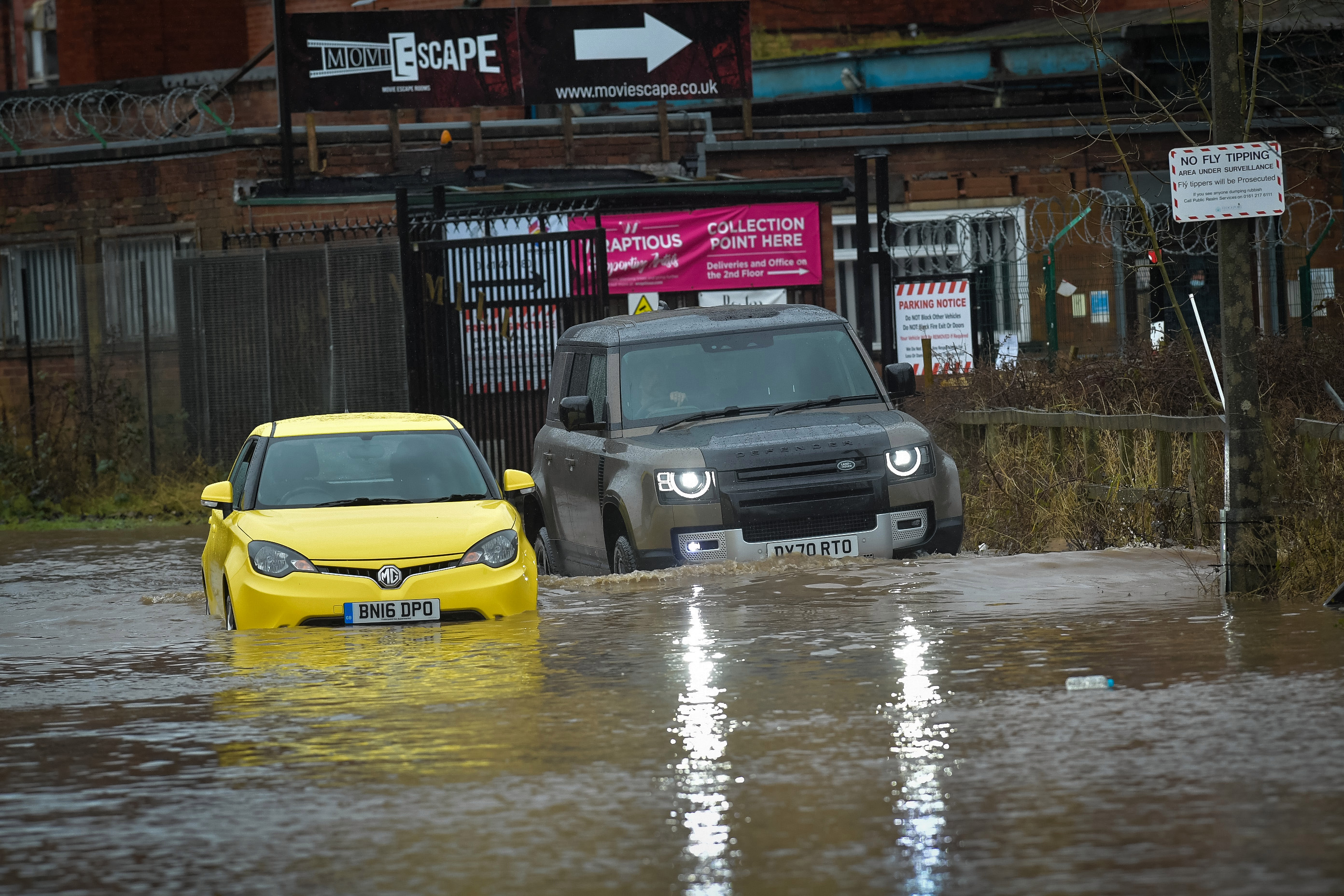 Two cars are seen partially submerged in Stockport, Lancashire following heavy rainfall overnight