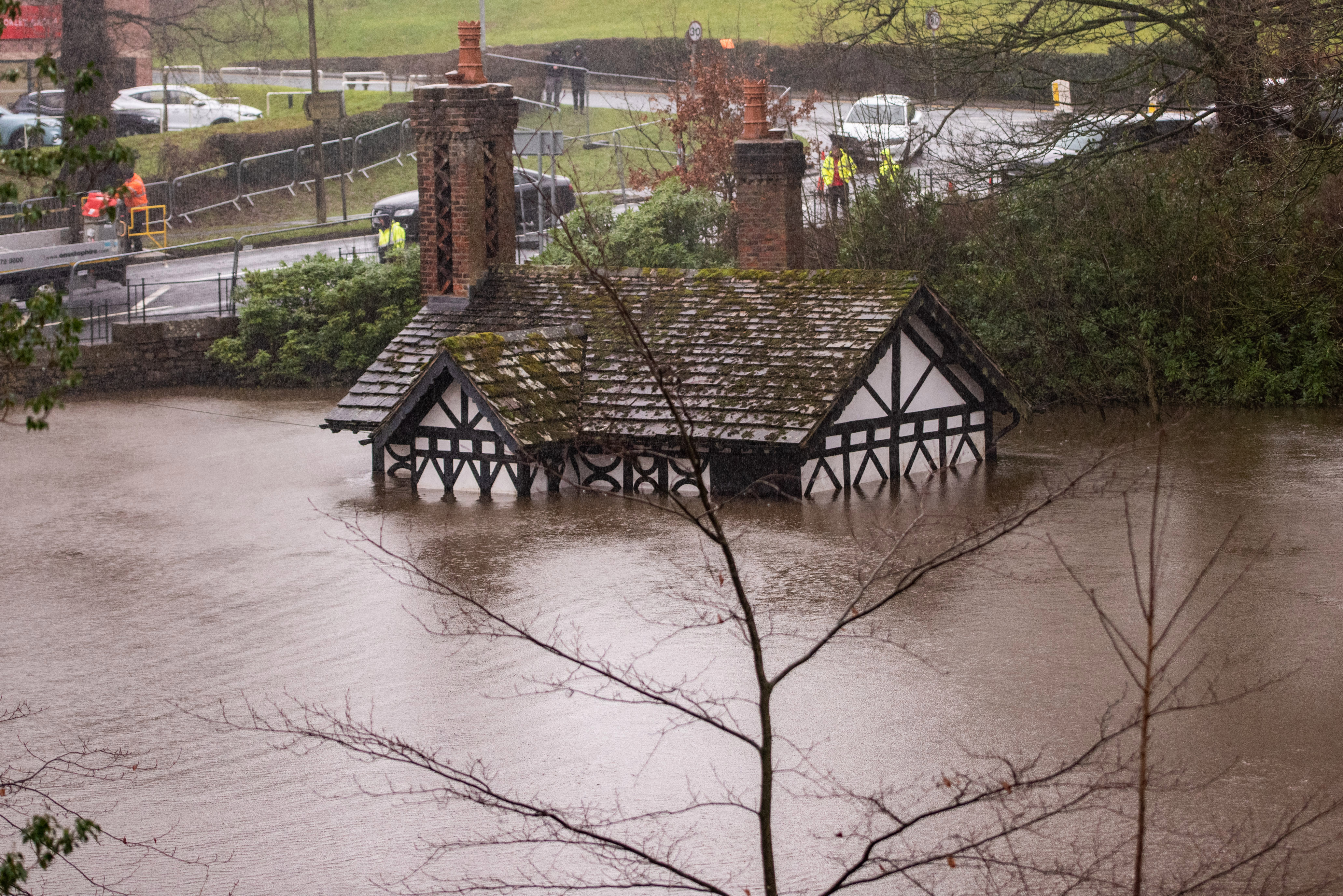 Council workers attempt to pump out water from the flooded Ackhurst Lodge in Chorley, Lancs, this morning