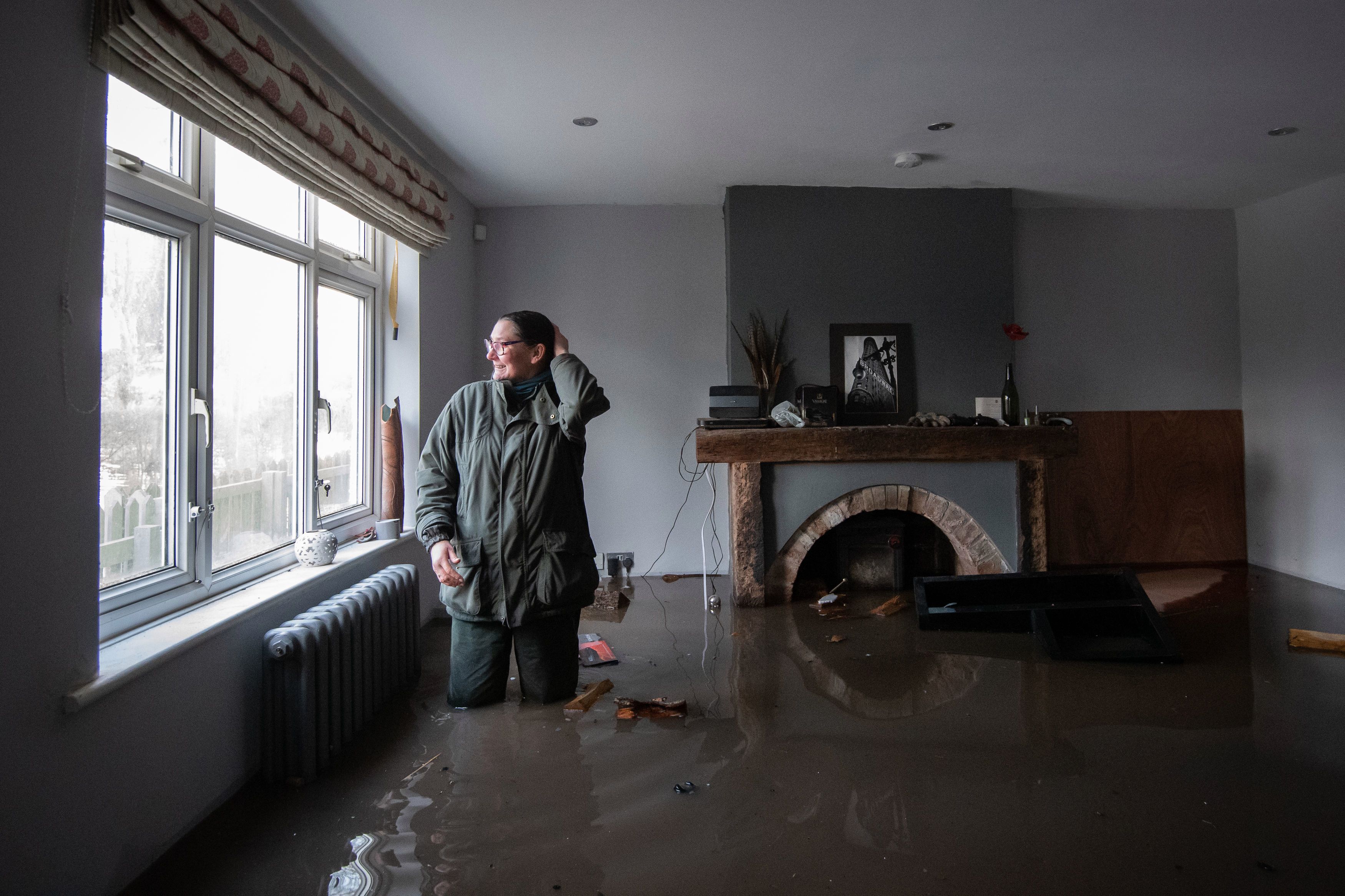 Gabrielle Burns-Smith looks out from her flooded home on the outskirts of Lymm in Cheshire