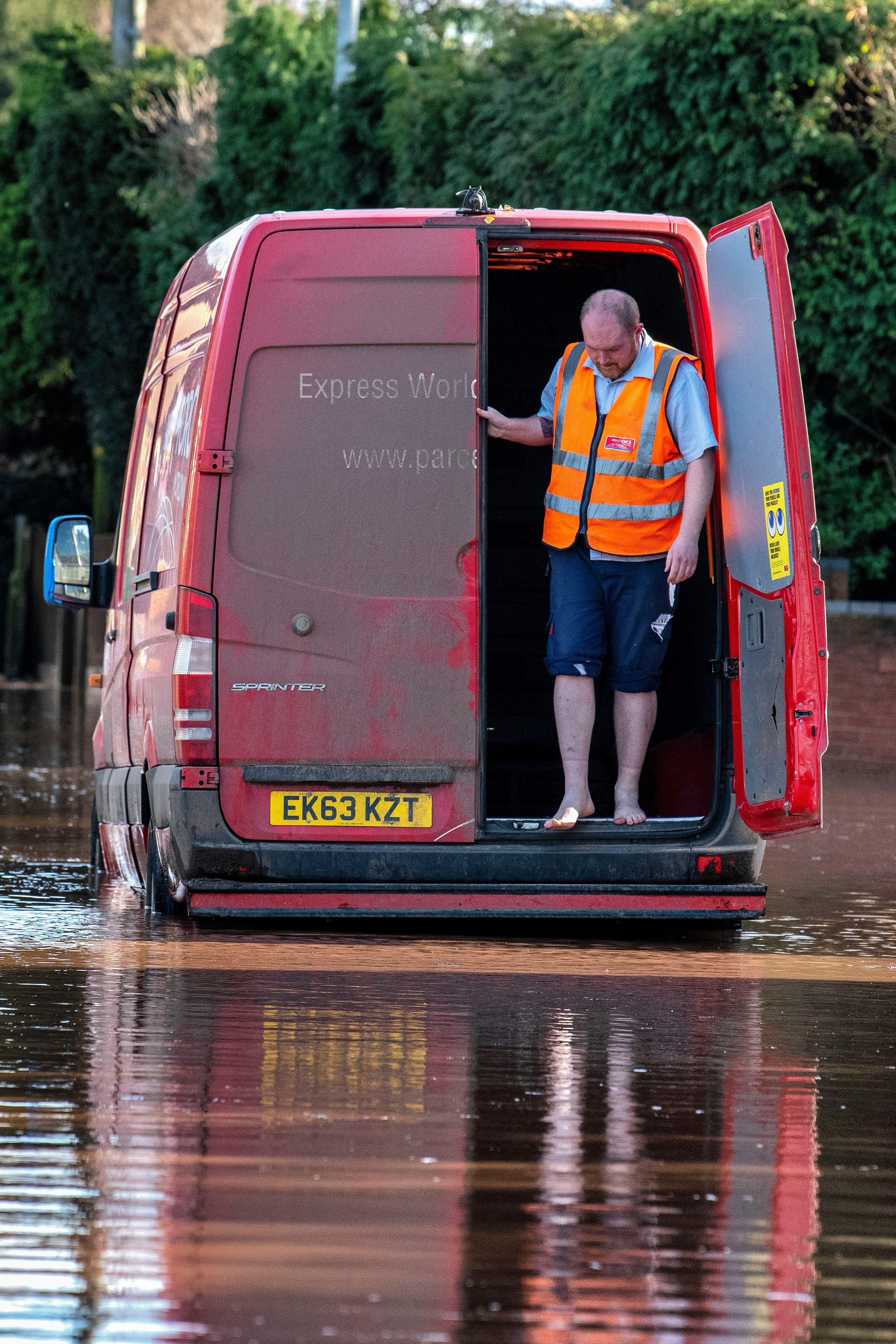 A Parcelforce delivery van is stranded in flood water in Hereford as the River Wye bursts its banks