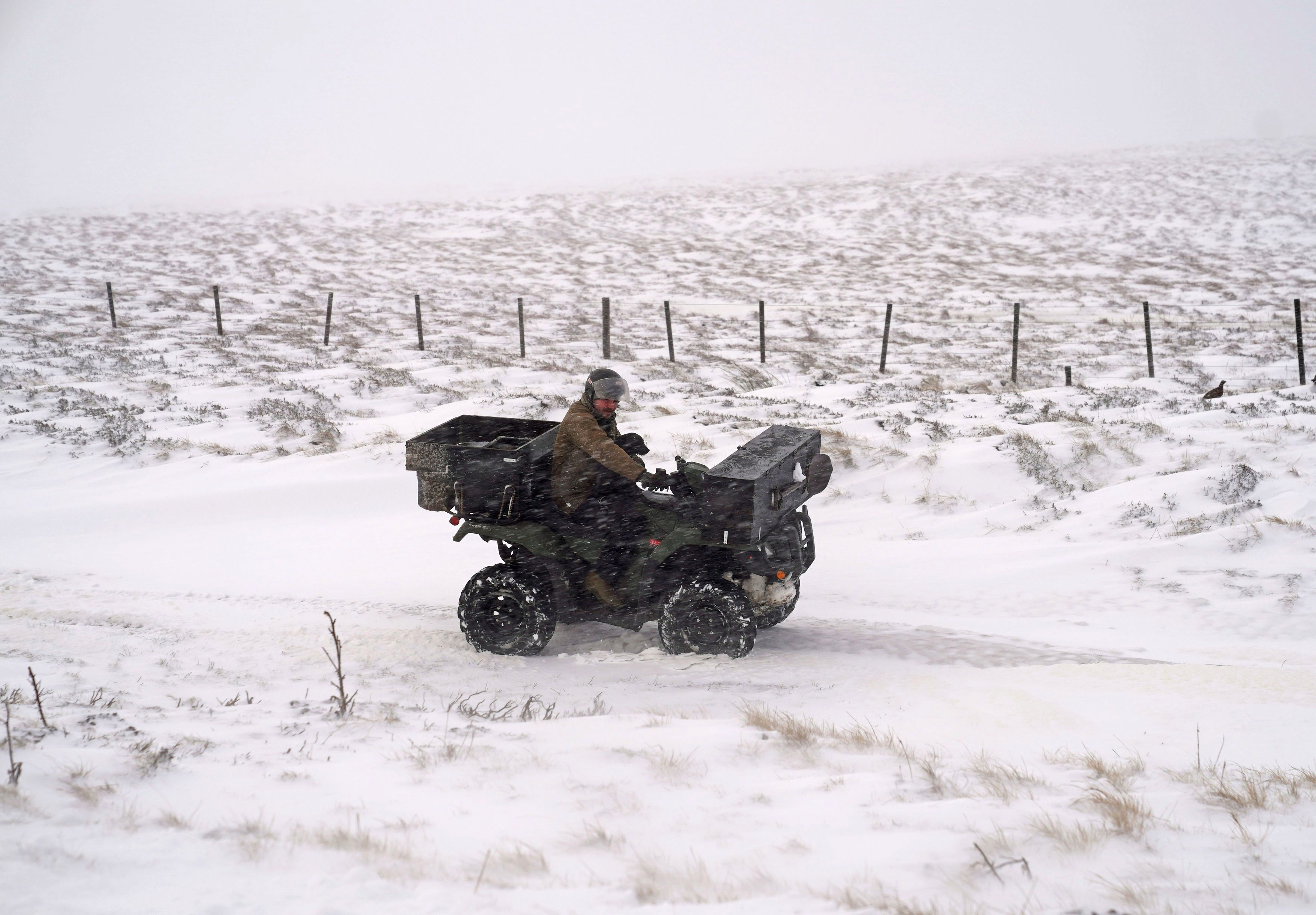 A man rides a quad bike through Allenheads, Northumberland following heavy snow overnight
